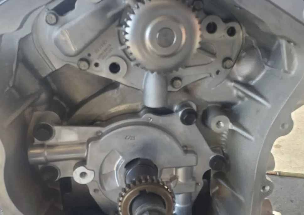 Primer plano de los engranes de distribución y la tapa delantera de un motor usado en Villanueva Auto
